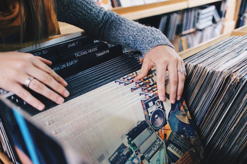 woman flips through a box of vintage LP records
