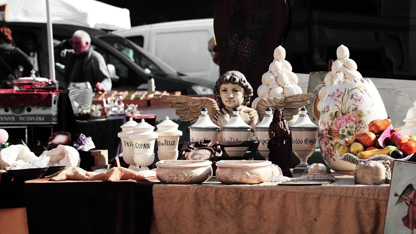 display of porcelain jars, bowls, and figures on table in street
