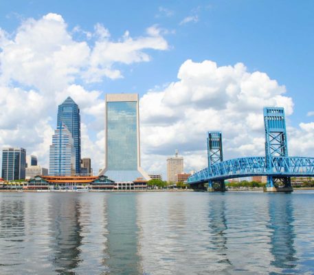 The cityscape of Jacksonville, Florida on the water on a sunny day.