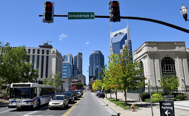 An intersection of a street in downtown Nashville, Tennessee with skyscrapers in the background.